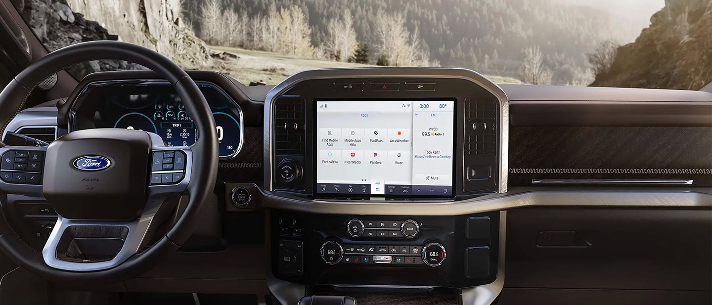 Truck interior showing dashboard, steering wheel, and large central touchscreen display.